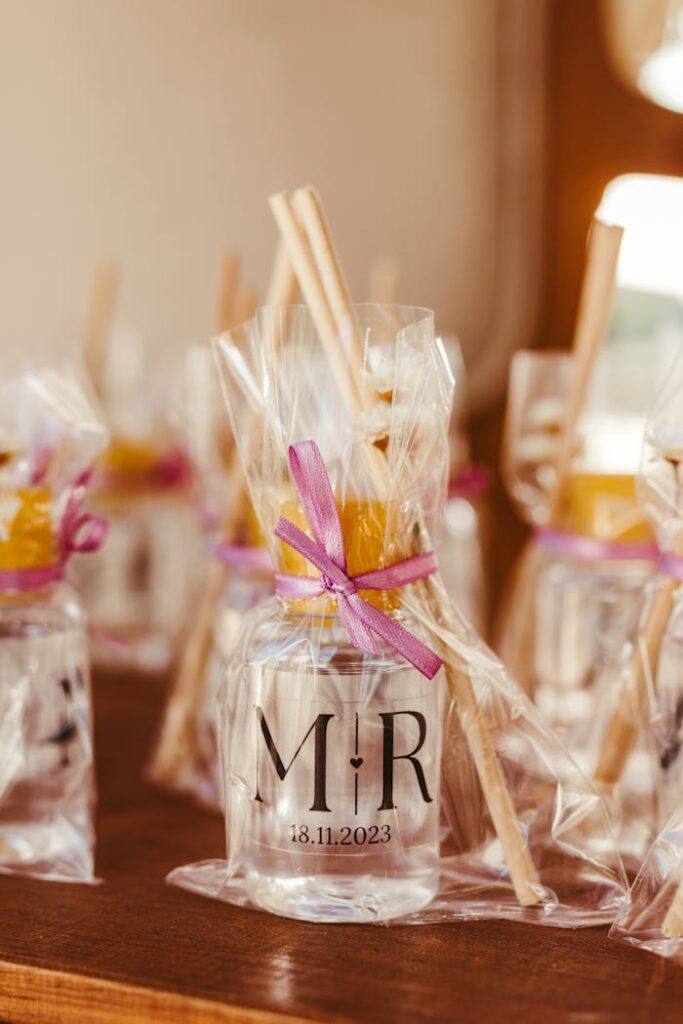 Sophisticated wedding table decor featuring elegant glass holder with purple ribbon and personalized detail.